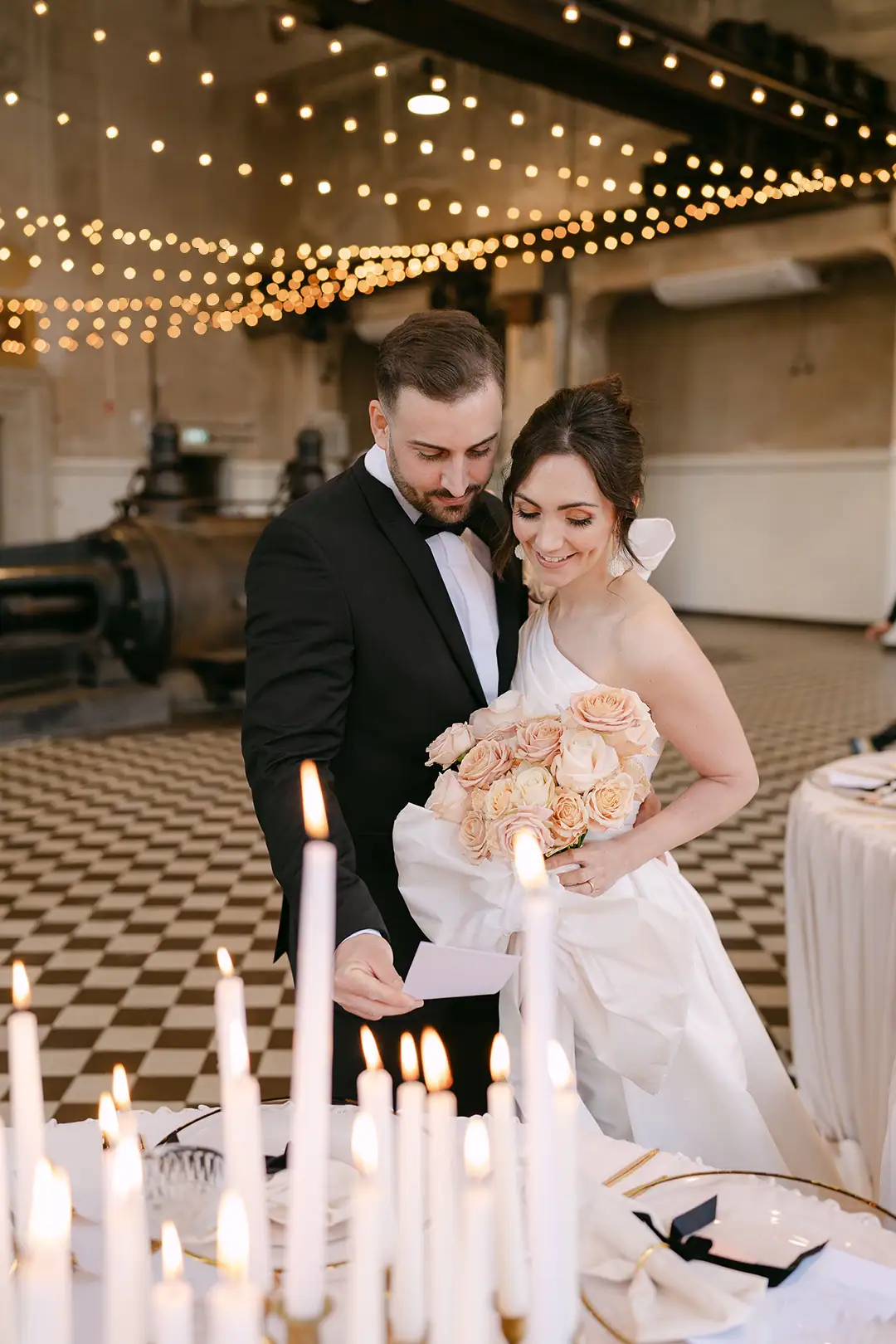 Hochzeitspaar bewundert ihre Hochzeitspapeterie in Schwarzweiß in der Alten Maschinenhalle