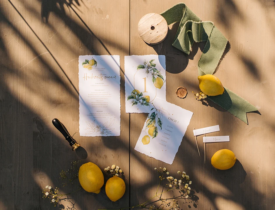 Menükarte, Tischnummer und Sitzplankarten im mediterranen Design mit frischen Zitronen und handgerissenen Papierkanten.