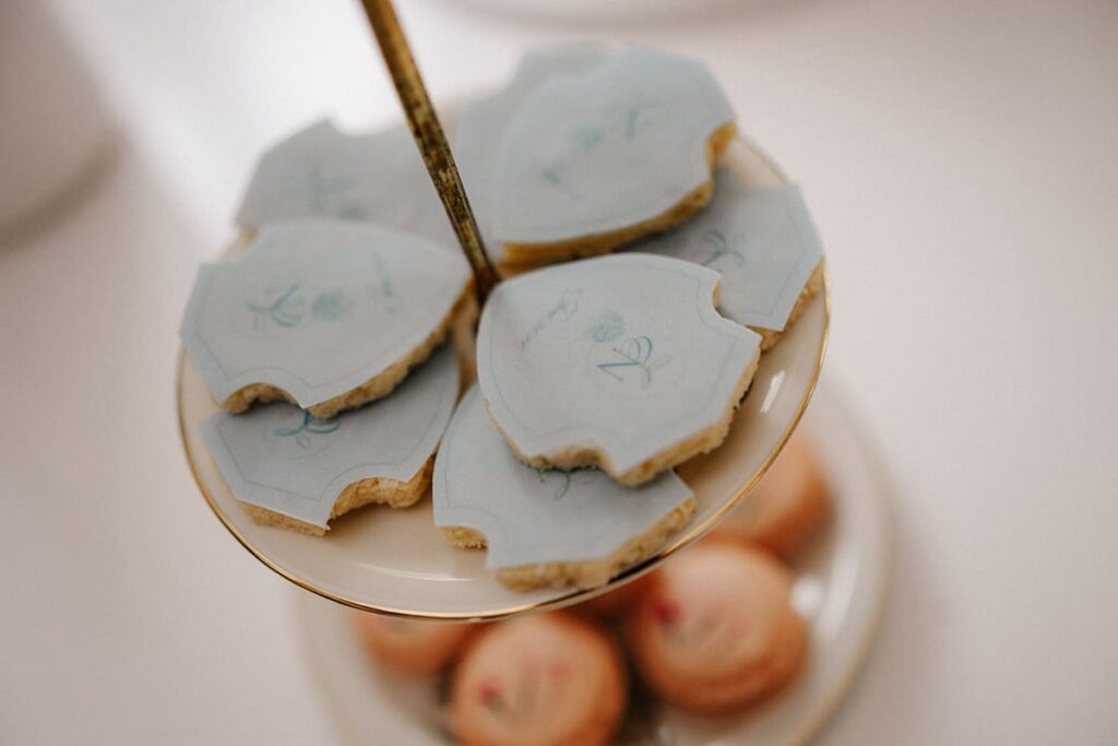 Sweet-Table-Kekse mit hellblauer Monogramm-Oblate auf goldberandetem Etagere